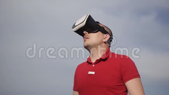 人类在蓝天的背景下使用虚拟现实眼镜视频的预览图