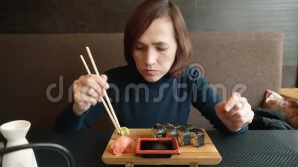女人在吃寿司那女孩正在用棍子吃面包卷视频的预览图