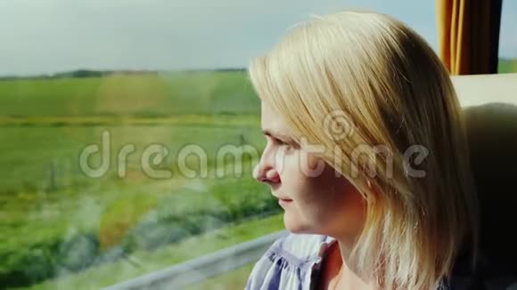 一位年轻女子乘公共汽车旅行从窗外看风景如画的风景很快就经过了视频的预览图