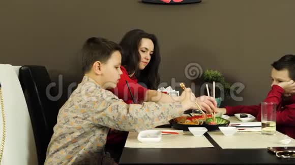 一群快乐迷人的朋友和孩子们一起在寿司店聊天吃寿司视频的预览图