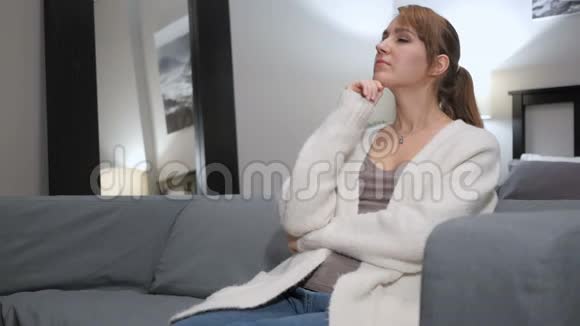女人思考坐在卧室的沙发上视频的预览图
