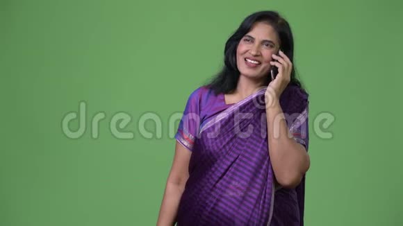 成熟快乐美丽的印度女人一边打电话一边思考视频的预览图