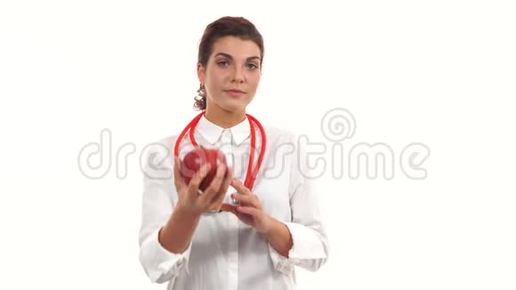 年轻友好的女性营养学家展示一个红苹果建议健康饮食青年专业人士肖像视频的预览图