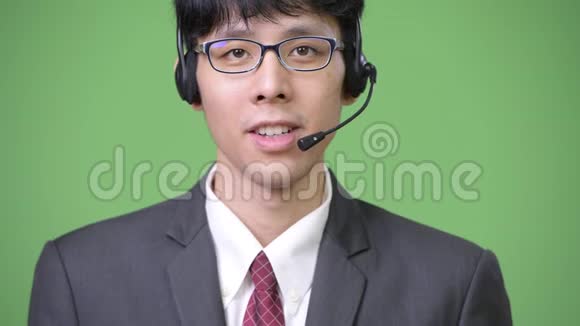 年轻的亚洲商人微笑着作为呼叫中心代表工作视频的预览图