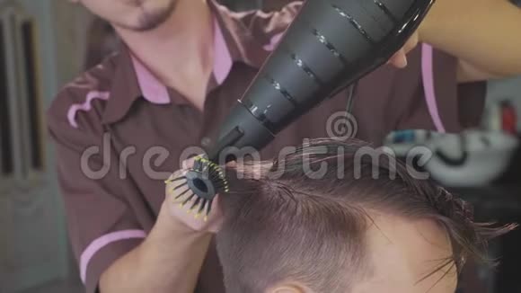 理发师给理发店的男顾客做梳子和吹风机的发型视频的预览图