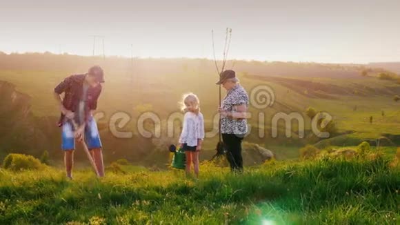 一个有两个孙子的老妇人一个男孩和一个女孩一起种一棵树在此背景下视频的预览图