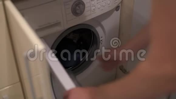 一个人从洗衣机里抽出衣服为他妻子的到来做准备视频的预览图