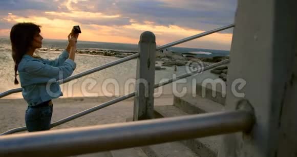 女人用手机点击海滩4k的照片视频的预览图