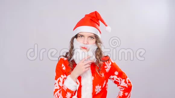 带着红色绒毛圣诞帽和胡须的有趣圣诞女孩视频的预览图