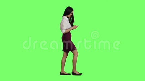 亚洲女孩走在街上手机看着有趣的照片绿色屏幕cc视频的预览图