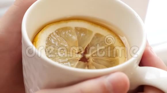 冷女孩喝着热的金茶柠檬放在窗边视频的预览图