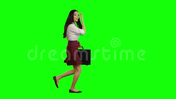 一个手里拿着公文包的亚洲女孩正在跑去谈话绿色屏幕视频的预览图