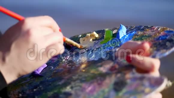 夏天户外艺术家的女性手的特写和调色板与油漆艺术家混合油漆与刷子视频的预览图
