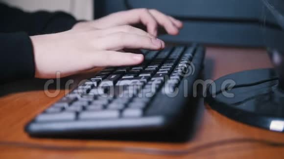 穿黑衬衫的人在电脑旁的键盘上打字视频的预览图