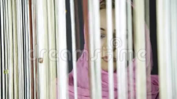 年轻的穆斯林阿拉伯女人穿着粉红色的头巾喝着咖啡看着窗外视频的预览图