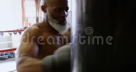 4k拳击袋上练习拳击的老人视频的预览图