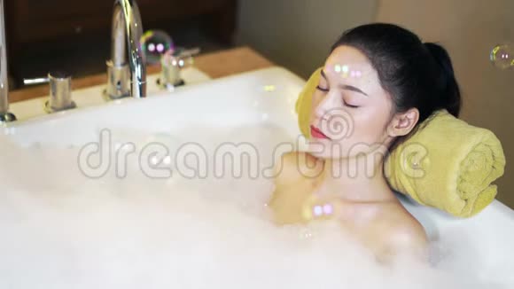 在浴缸里闭上眼睛的女人视频的预览图