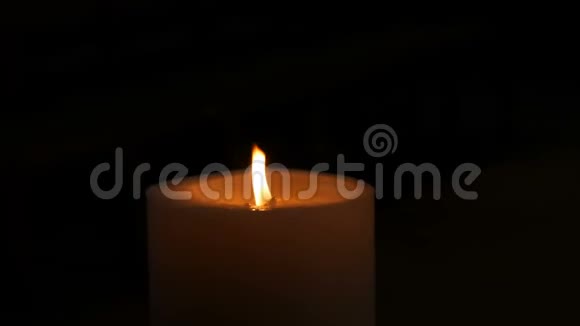 巨大的白色蜡烛在黑暗中燃烧夜晚的烛光近景视频的预览图