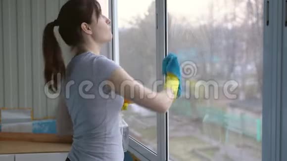 戴手套洗窗户的漂亮黑发女人视频的预览图