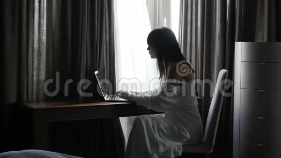 女人在桌子上打手提电脑视频的预览图