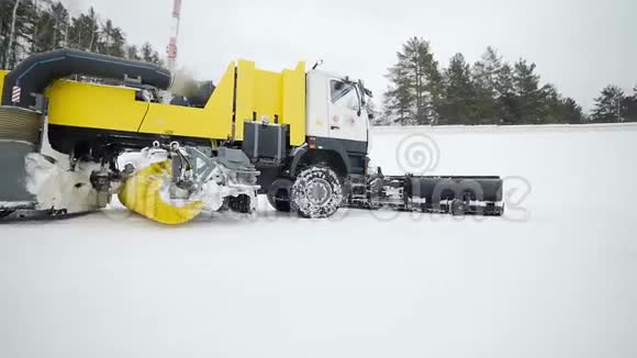 大桶和旋转刷子的重型车轮机械正在驾驶以清除雪和清洁雪中的道路视频的预览图