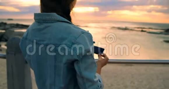 女人用手机点击海滩4k的照片视频的预览图