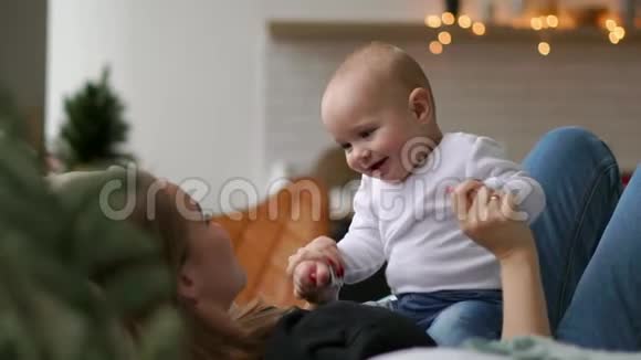 生命中最美好的时刻一位充满爱心的年轻母亲在雪白的毯子上在洁白的毯子上拥抱一个哺育的儿子视频的预览图