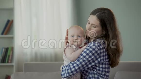美丽的年轻妈妈和可爱的宝贝女儿拥抱和微笑幸福的未来视频的预览图