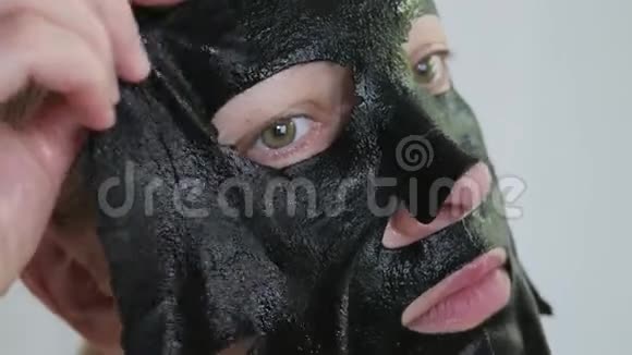女40岁脸上戴着一个恢复青春活力的黑色组织面膜视频的预览图