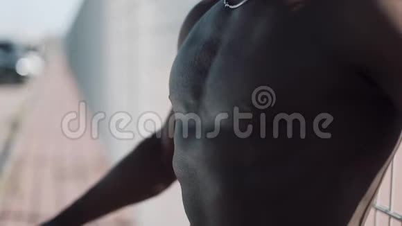 显示完美腹肌的男人肌肉黑男健美站在体育场外的男子展示了他的视频的预览图