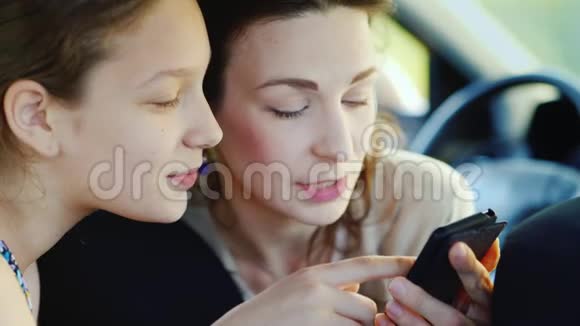 母亲和女儿11年的肖像可爱沟通一起用手机一起快乐视频的预览图