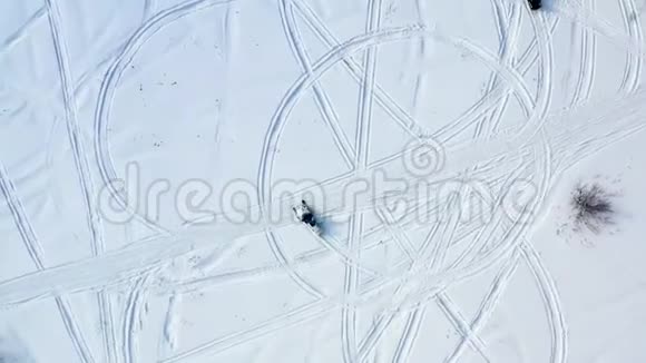 乘坐雪地摩托的俯视图录像两辆雪地摩托在雪地上留下脚印的顶部景色视频的预览图