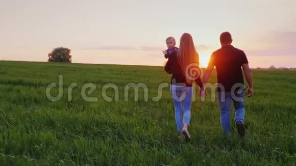 有宝宝的年轻幸福家庭日落时他们去了风景如画的绿野斯塔迪加姆射击后视视频的预览图