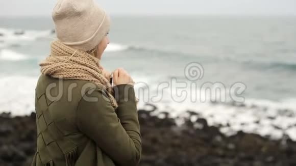 站在海边的年轻美女的后景看着什么用手指指着这个视频的预览图