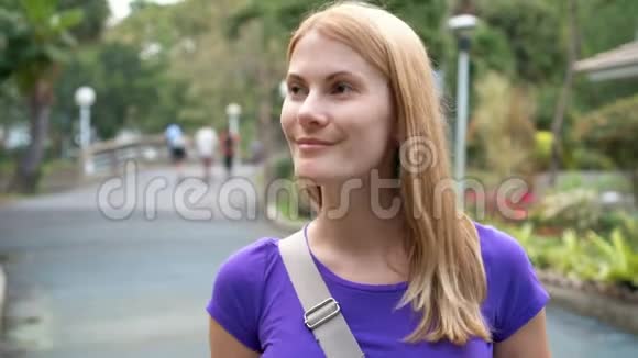 美丽的女孩走在公园里微笑着在热带国家度假时玩得开心视频的预览图