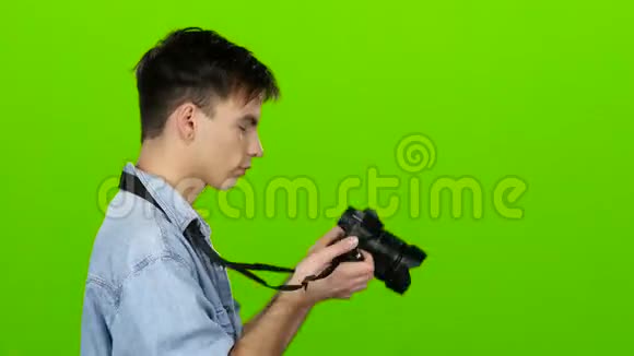 他拿着相机拍着别人的美丽照片绿色屏幕视频的预览图