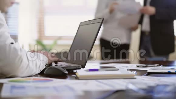 工作人员在笔记本电脑上做笔记两位同事在办公室讨论文件视频的预览图