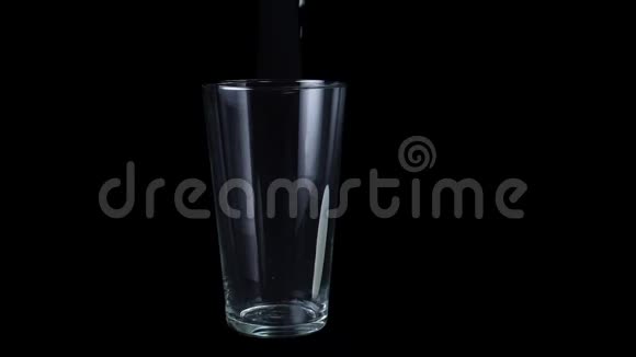 杯中的特写倒入白色酸奶框架在透明的大玻璃中倒入白色的浓稠液体分离出黑色视频的预览图