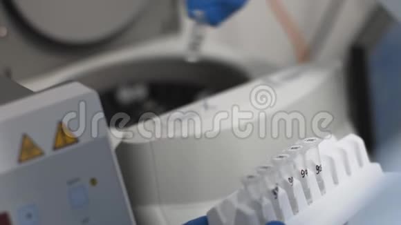 实验室技术人员从医用离心机抽取生物材料样品管视频的预览图