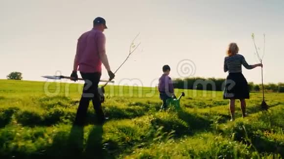 后景一家农民带着一个小儿子要种一棵树熊园工具和苹果树苗视频的预览图