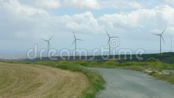 废弃的道路附近的现代风车旋转风电场未来技术视频的预览图