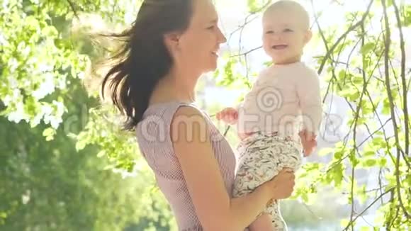微笑的孩子和妈妈一起笑绿色后院慢动作视频的预览图