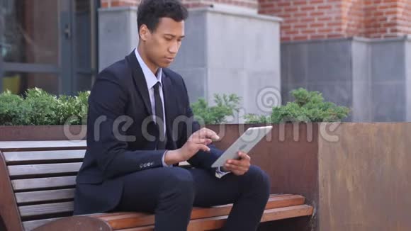 坐在长椅上使用平板电脑的设计师视频的预览图