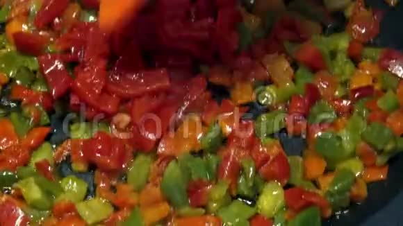 厨师在煎锅里煮红辣椒和青椒健康的蔬菜视频的预览图