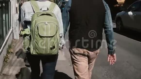 在阳光明媚的日子里年轻的游客夫妇在街上散步男人和女人在浪漫的约会视频的预览图