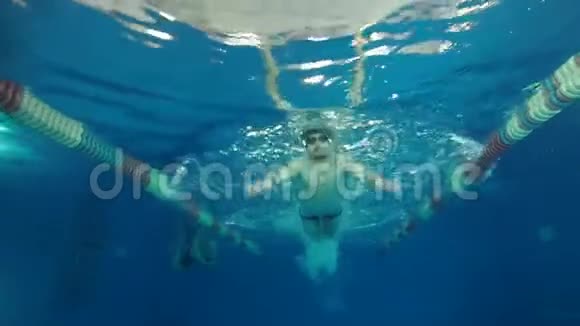 男子游泳运动员在游泳池中游泳蝶泳在水下慢动作视频的预览图