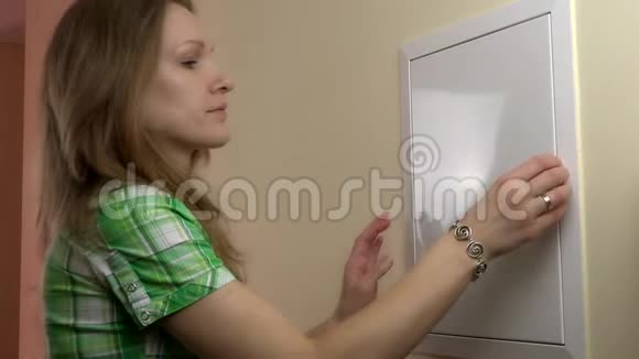 年轻女子在自己的客厅检查断路器4K视频的预览图