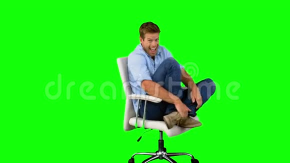 微笑的人在绿色屏幕上欢呼和转动转椅视频的预览图