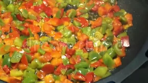 厨师在煎锅里煮红辣椒和青椒健康的蔬菜视频的预览图