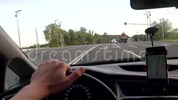 一个人在高速驾驶汽车用手握着车轮看着领航员视频的预览图
